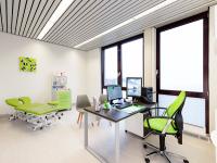 modernes behandlungszimmer mit grüner einrichtung und schreibtisch